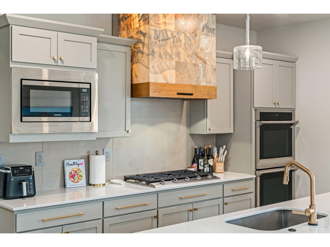 5018 Leopold Loop Timnath, CO 80547 - Photo 19 of 50 a kitchen with stainless steel appliances granite countertop a stove a sink and a microwave