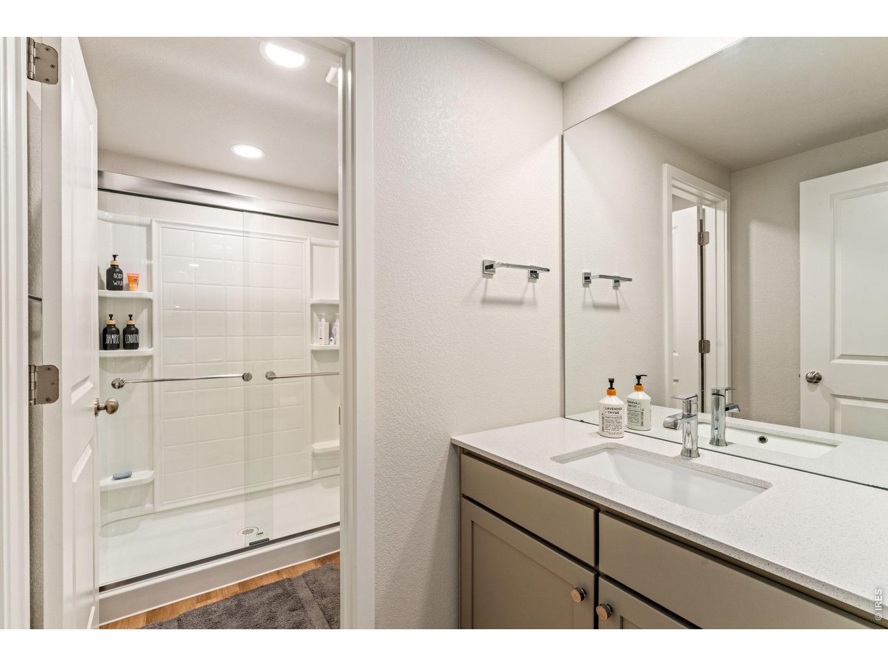 5018 Leopold Loop Timnath, CO 80547 - Photo 39 of 50 a bathroom with a shower sink vanity and mirror