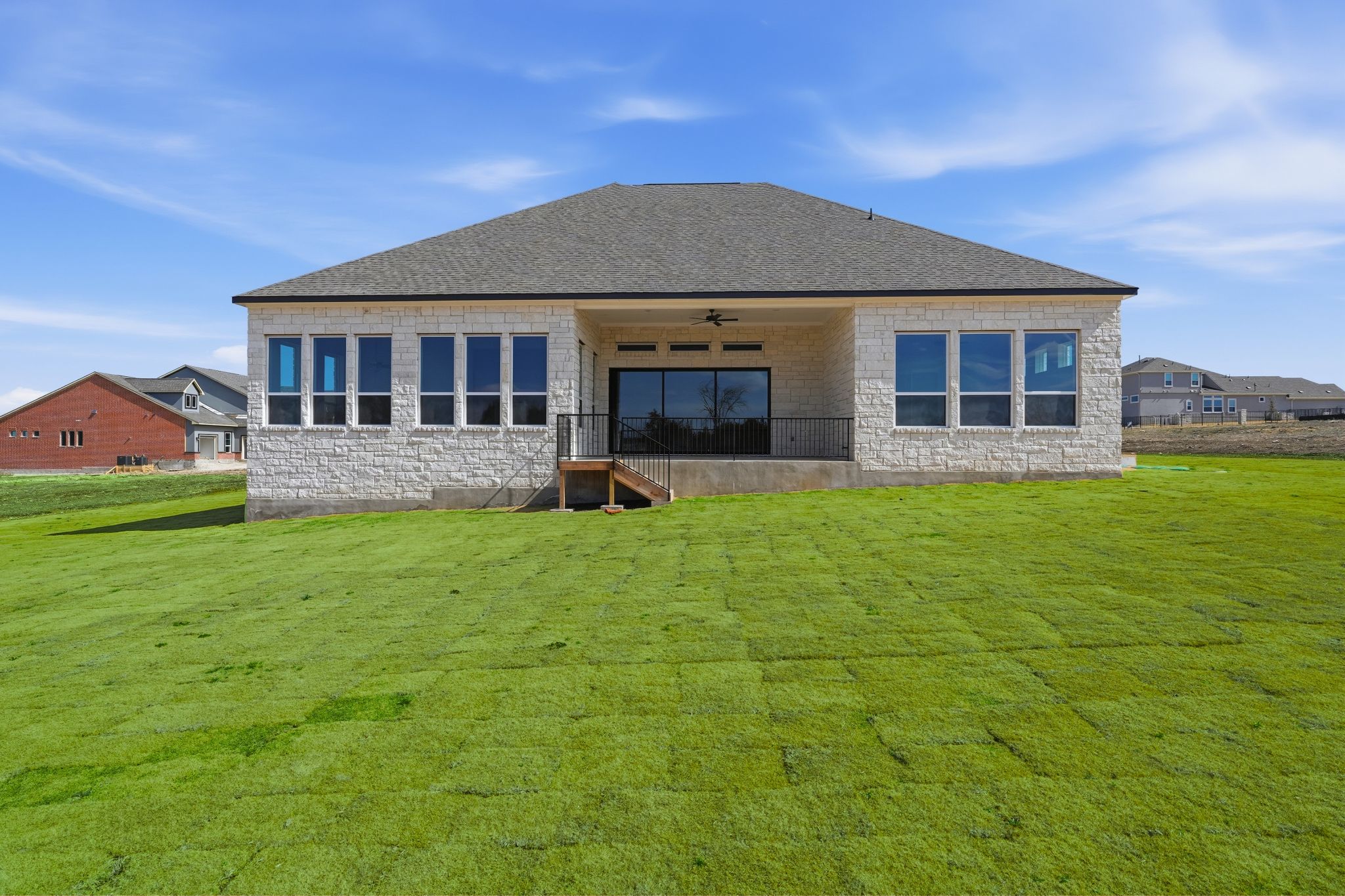 1209 Doelling Drive Georgetown, TX 78633 - Photo 28 of 31 Rear view of property featuring stone siding, ceiling fan, a patio, a lawn, and roof with shingles