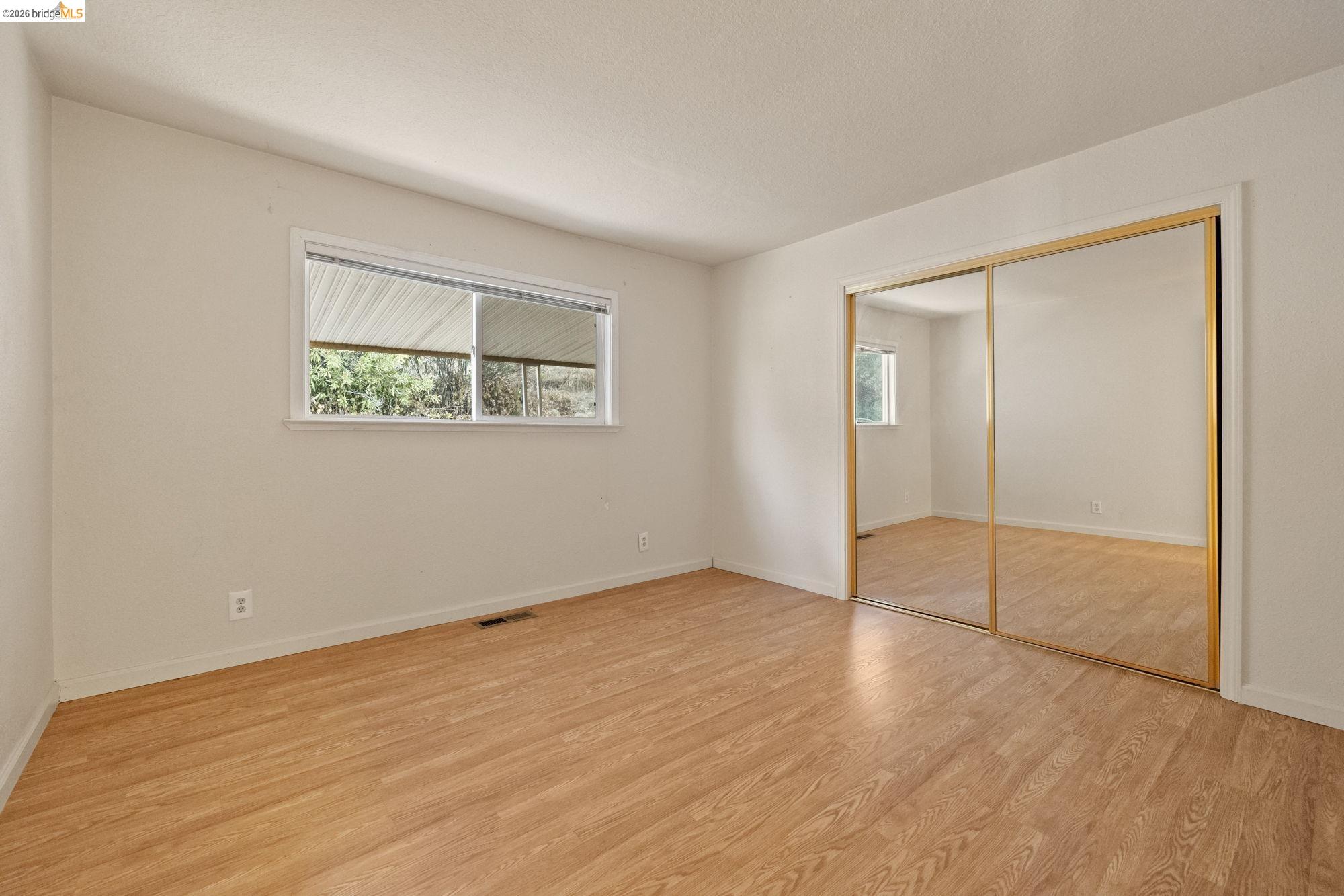 13904 Tuolumne Road Sonora, CA 95370 - Photo 18 of 31 an empty room with wooden floor and windows
