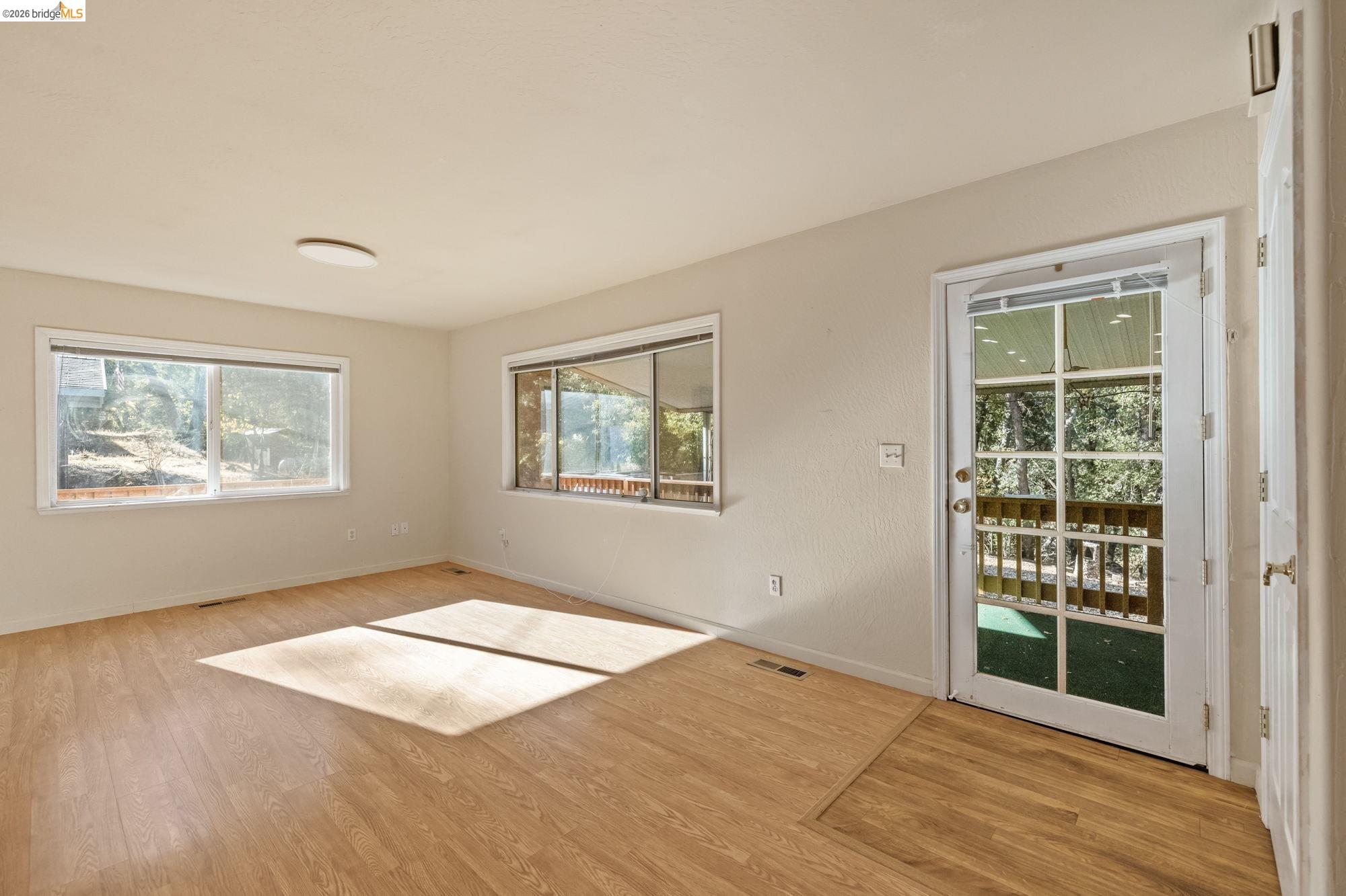 13904 Tuolumne Road Sonora, CA 95370 - Photo 3 of 31 a view of an empty room with wooden floor and a window