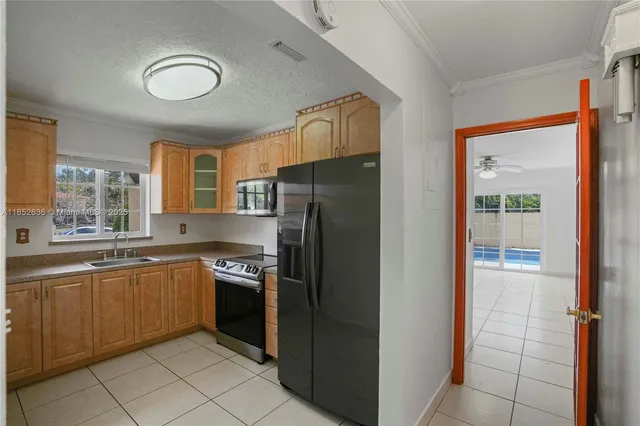 a kitchen with stainless steel appliances granite countertop a refrigerator and a sink