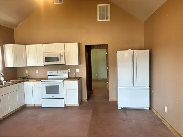 a kitchen with white cabinets and white appliances