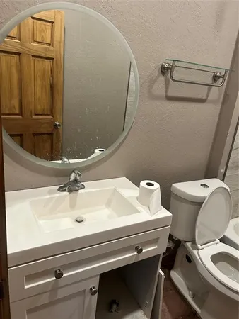 a bathroom with a sink mirror vanity and toilet