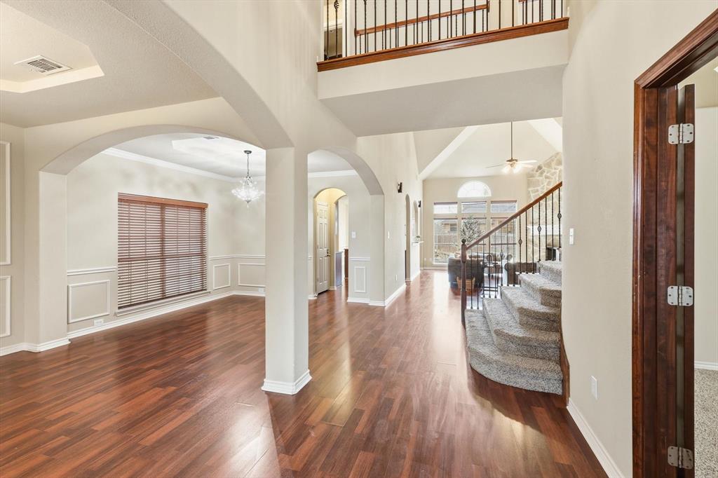 5038 West Fall Drive Midlothian, TX 76065 - Photo 9 of 40 Entryway with a decorative wall, arched walkways, wainscoting, dark wood-style flooring, and a chandelier