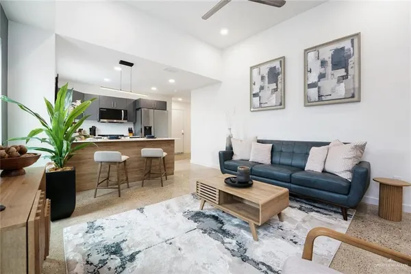 a living room with furniture a flat screen tv and a kitchen view