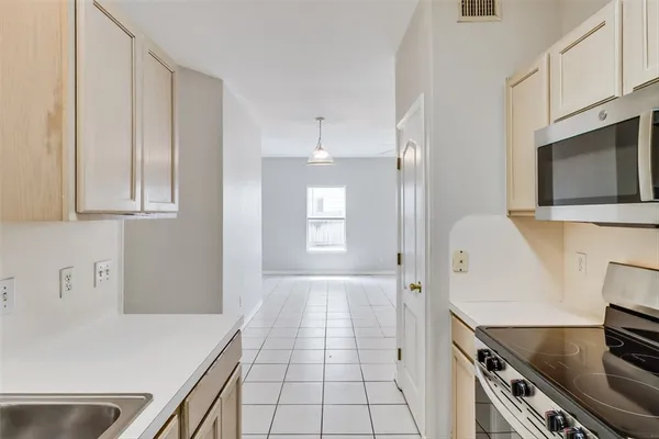 a kitchen with granite countertop a sink stove and refrigerator
