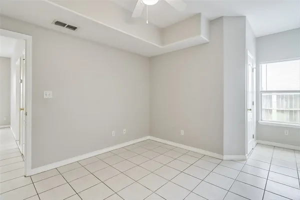 an empty room with windows and fan