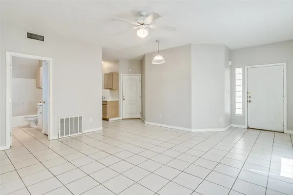 an empty room and chandelier fan in kitchen