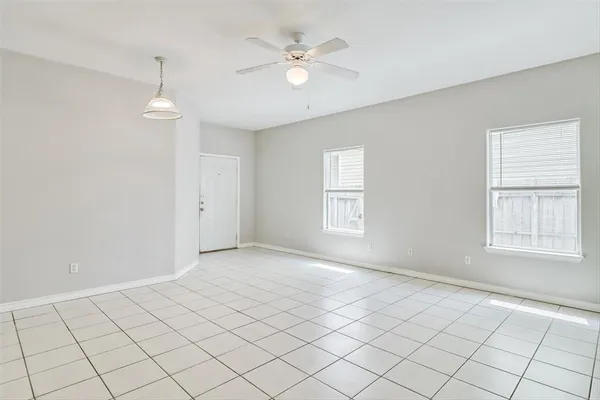 an empty room with windows and ceiling fan