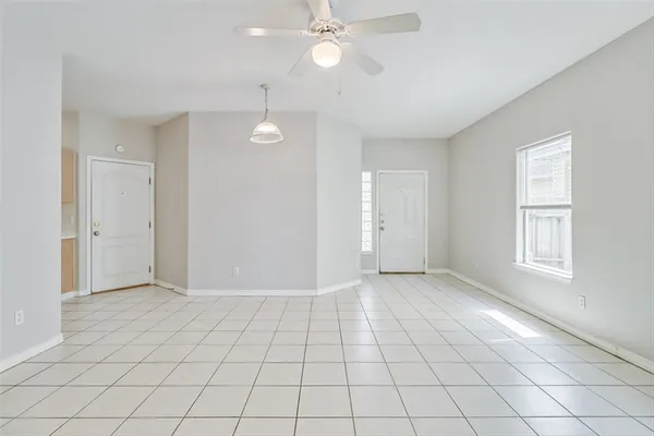 an empty room with fan and windows