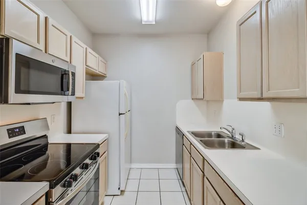 a kitchen with stainless steel appliances a stove sink microwave and refrigerator