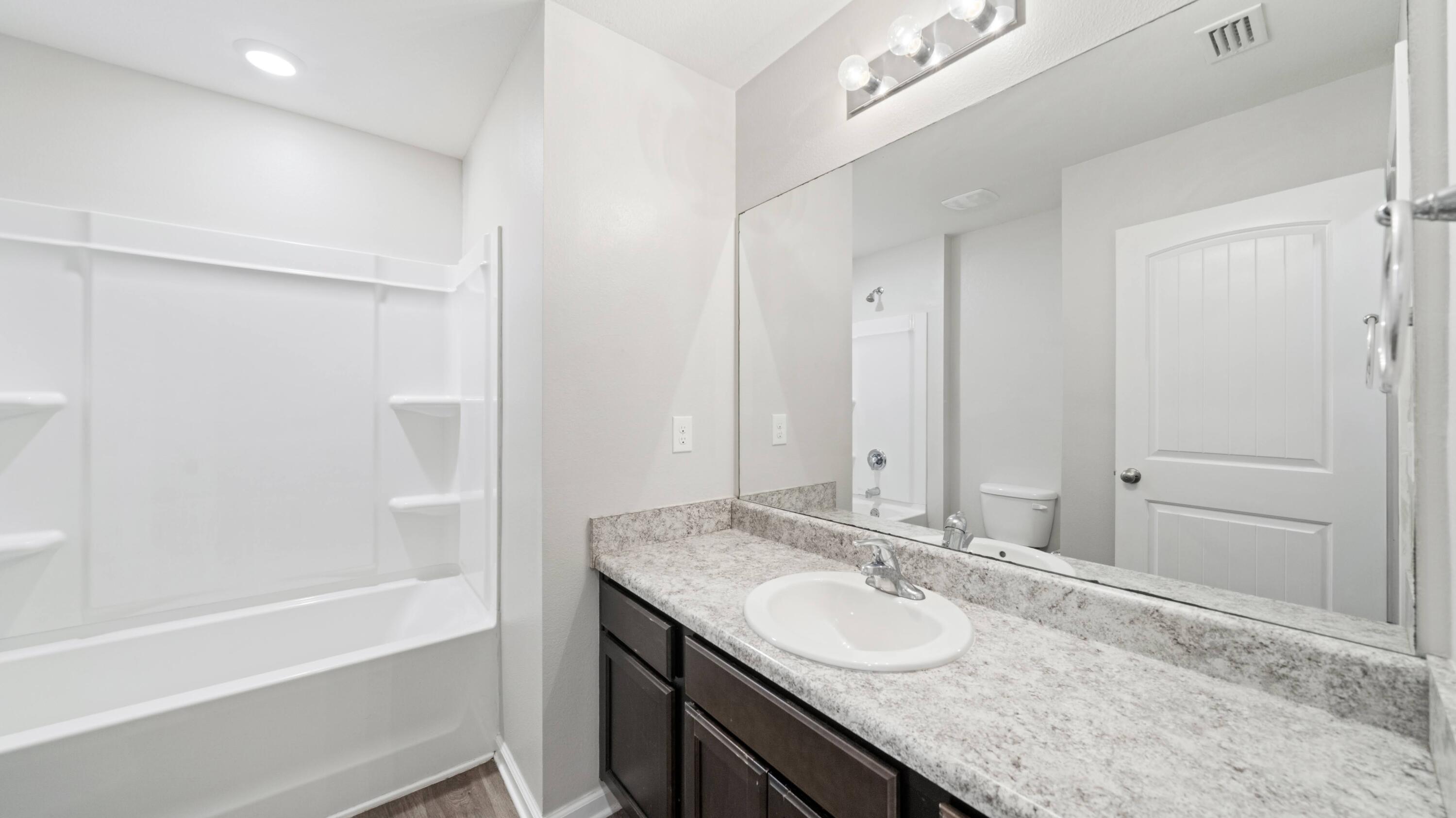 3927 Alva Thomas Road Panama City, FL 32404 - Photo 29 of 46 a bathroom with a granite countertop sink and a mirror
