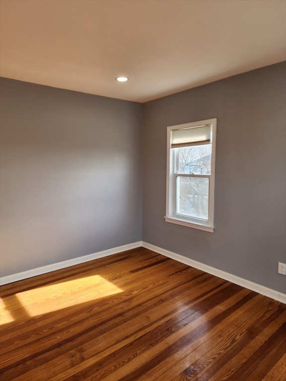 146 Middlesex Street, Unit 3 Fall River, MA 02723 - Photo 4 of 9 an empty room with wooden floor and windows