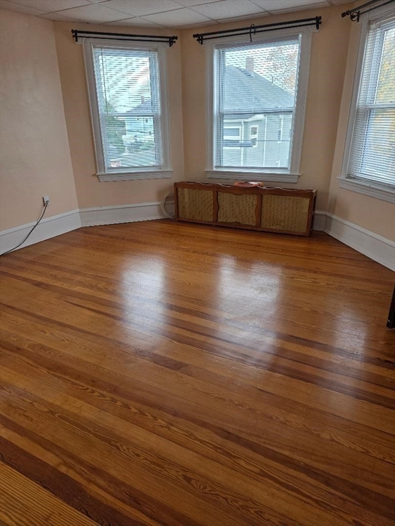 146 Middlesex Street, Unit 2 Fall River, MA 02723 - Photo 4 of 19 an empty room with wooden floor and windows