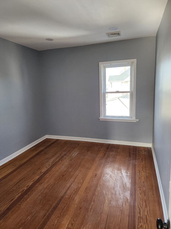 146 Middlesex Street, Unit 3 Fall River, MA 02723 - Photo 7 of 9 an empty room with wooden floor and windows