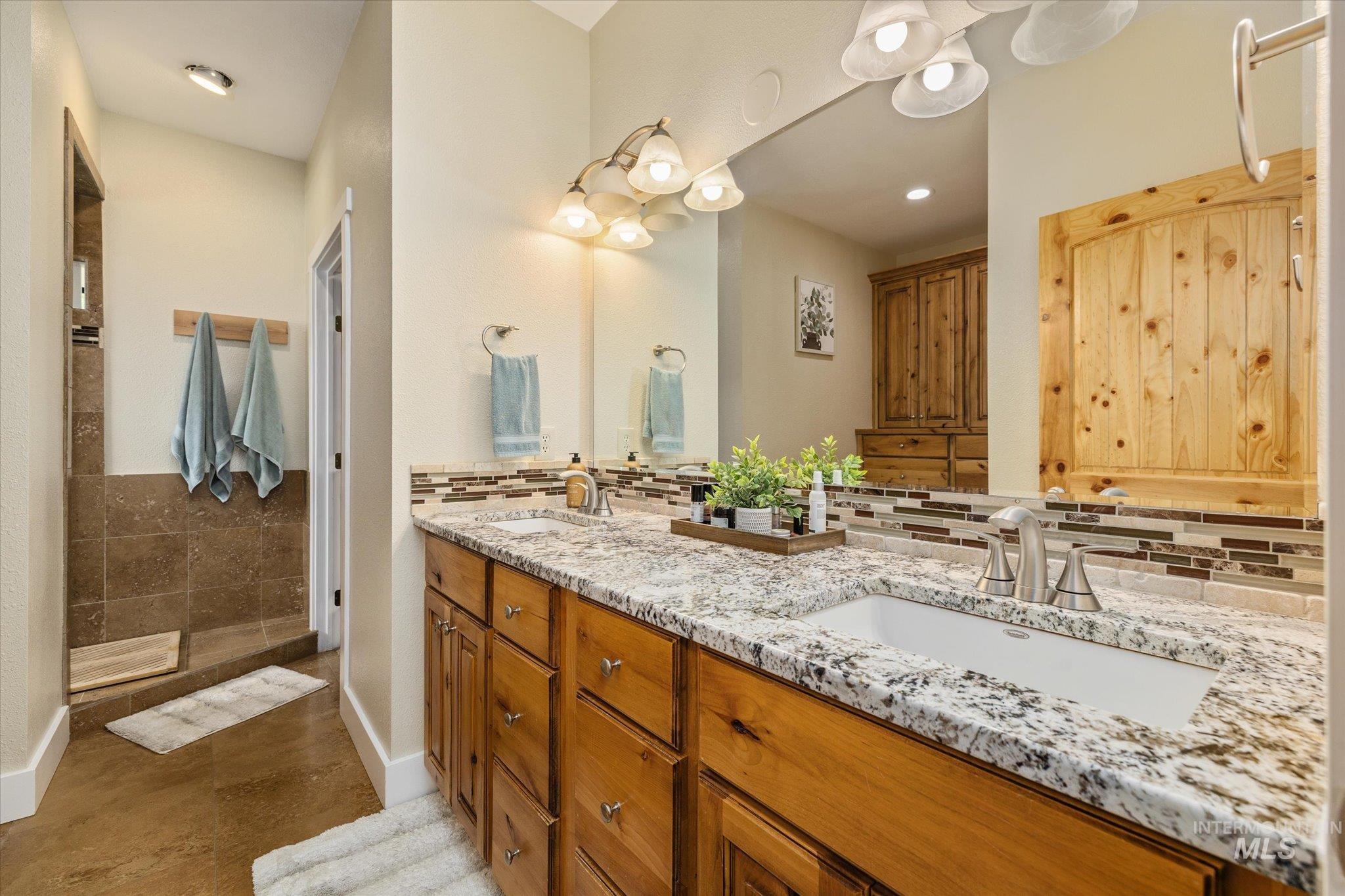 1140 Edgemont Road Emmett, ID 83617 - Photo 17 of 50 Bathroom featuring a double vanity with granite countertops, wood cabinetry, and dual undermount sinks