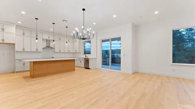 a large kitchen with stainless steel appliances kitchen island a large island in the center and a large window