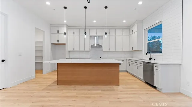 a large kitchen with stainless steel appliances granite countertop a stove a sink and a refrigerator