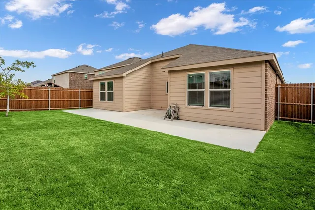 a backyard of a house with table and chairs