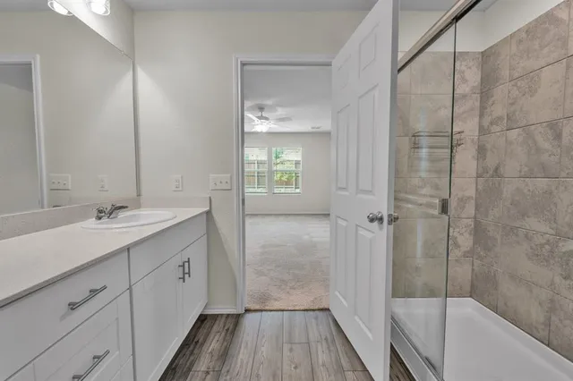 a bathroom with a double vanity sink a mirror and a bathtub