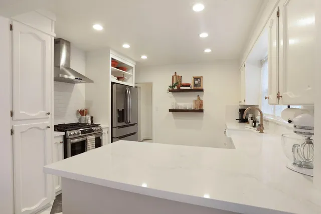 a kitchen with stainless steel appliances a sink stove and refrigerator
