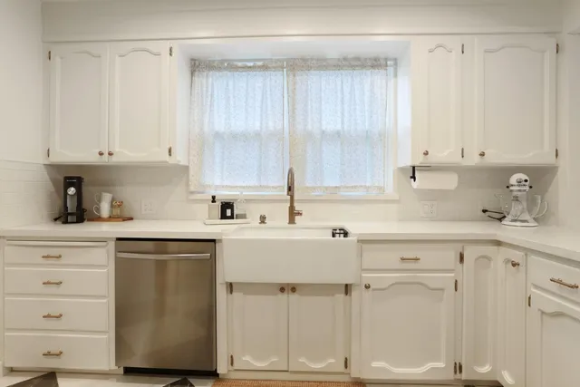 a kitchen with white cabinets and white appliances