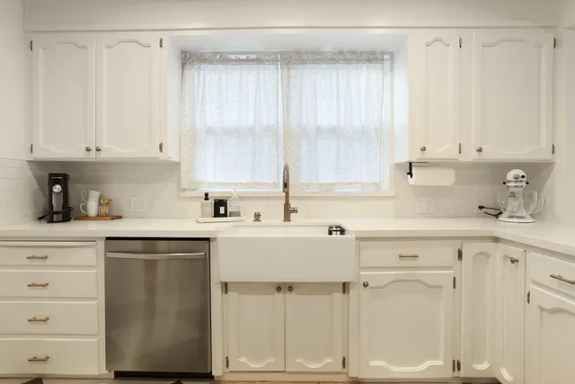 a kitchen with cabinets appliances and a window