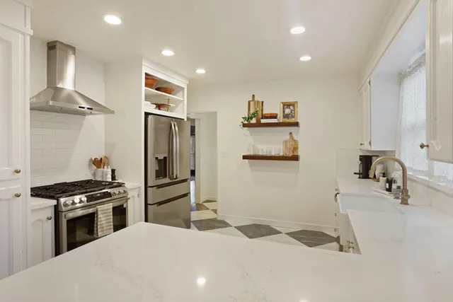 a kitchen with granite countertop a refrigerator stove and sink