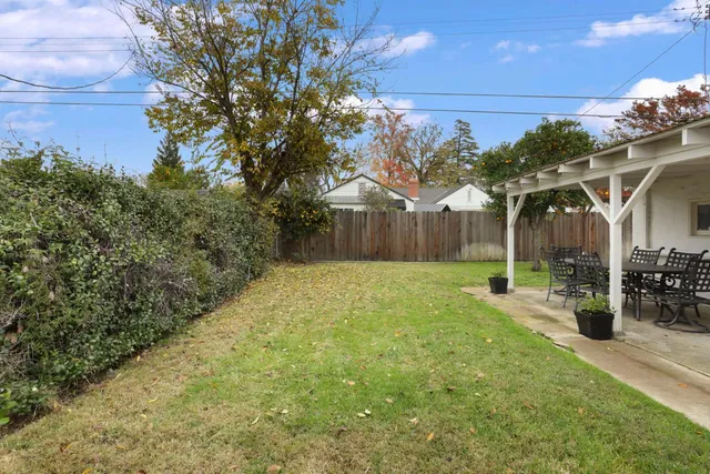 a view of a house with backyard and sitting area