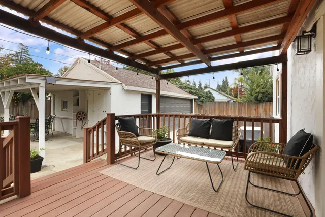 a view of a patio with a dining table and chairs with wooden floor
