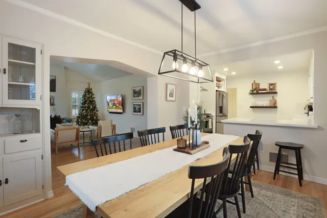 a view of a dining room and livingroom with furniture wooden floor a chandelier