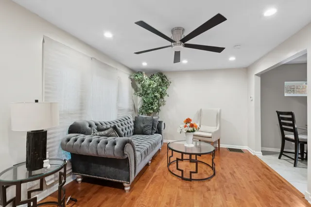 a living room with furniture and a ceiling fan