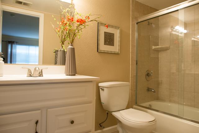 417 Kenbrook Circle San Jose, CA 95111 - Photo 9 of 22 a bathroom with a granite countertop sink toilet a mirror a vanity and shower
