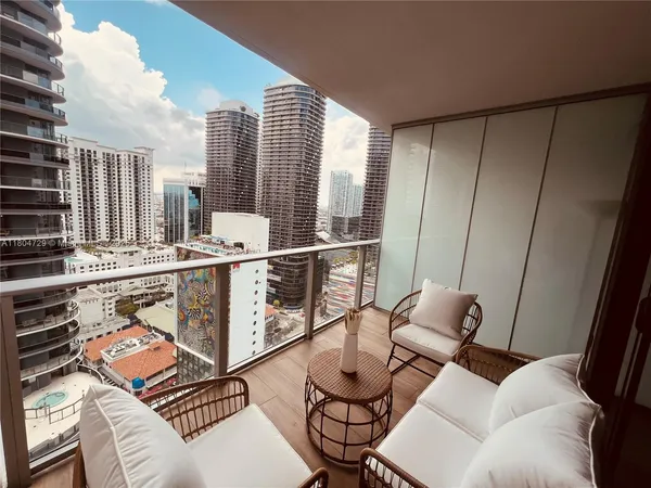 a balcony with furniture and next to a window