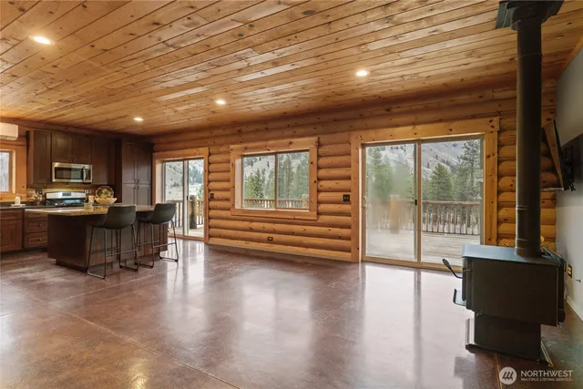 a living room with furniture floor to ceiling window and a flat screen tv