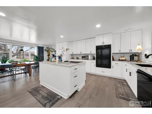 a kitchen with cabinets and wooden floor