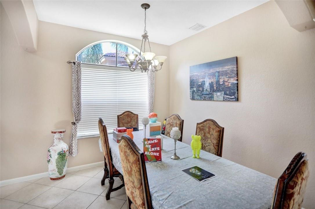 5257 Sancerre Circle Lake Worth, FL 33463 - Photo 14 of 46 a dining room with furniture and chandelier