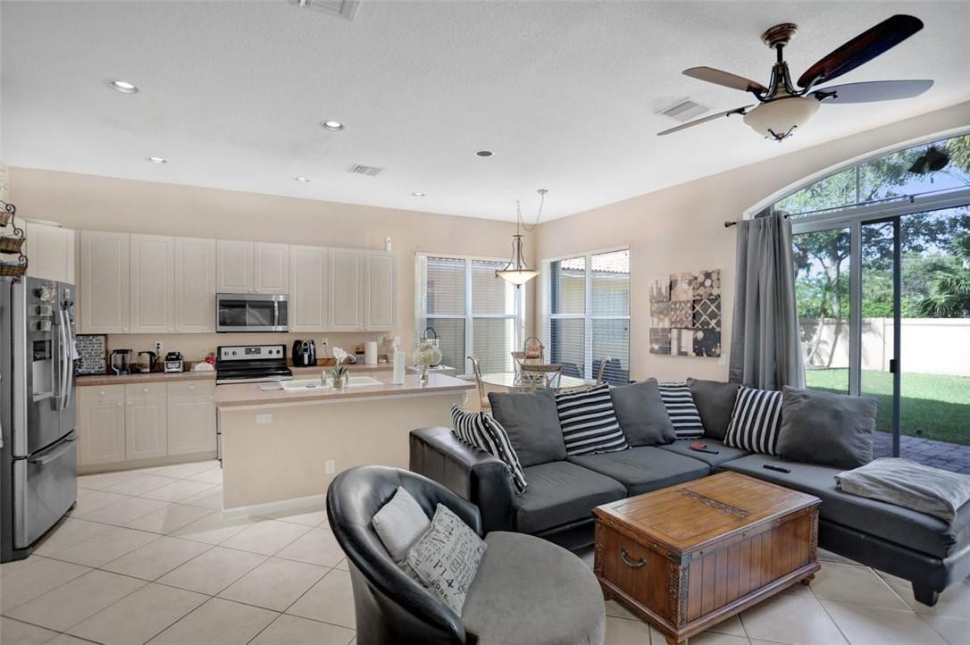 5257 Sancerre Circle Lake Worth, FL 33463 - Photo 18 of 46 a living room with furniture and a large window with kitchen view