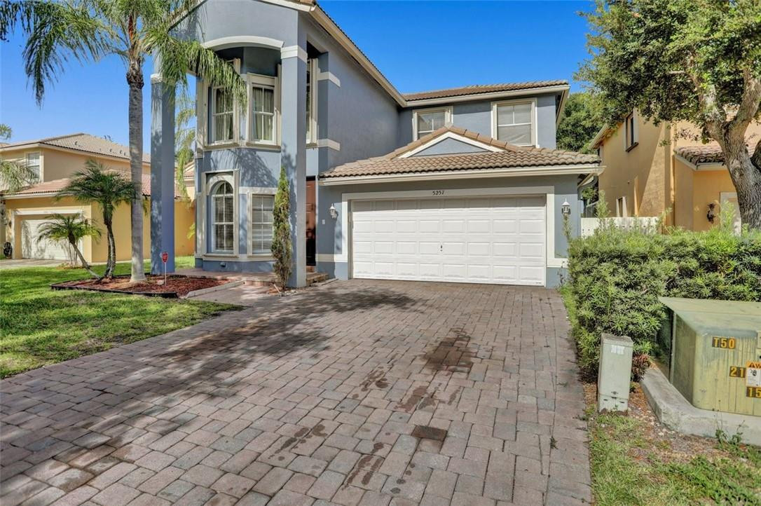 5257 Sancerre Circle Lake Worth, FL 33463 - Photo 2 of 46 a front view of a house with a yard and garage