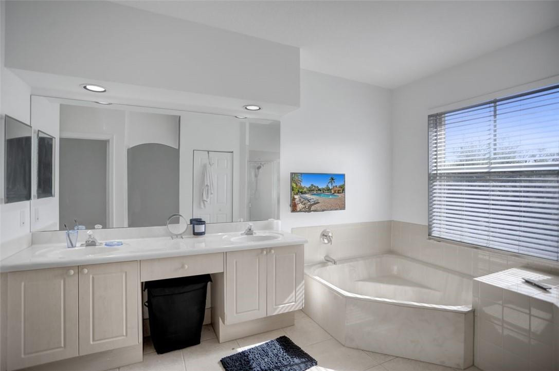 5257 Sancerre Circle Lake Worth, FL 33463 - Photo 30 of 46 a bathroom with a bathtub a sink a window and a mirror