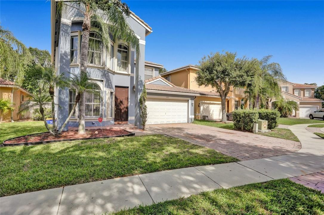 5257 Sancerre Circle Lake Worth, FL 33463 - Photo 3 of 46 a front view of a house with a yard