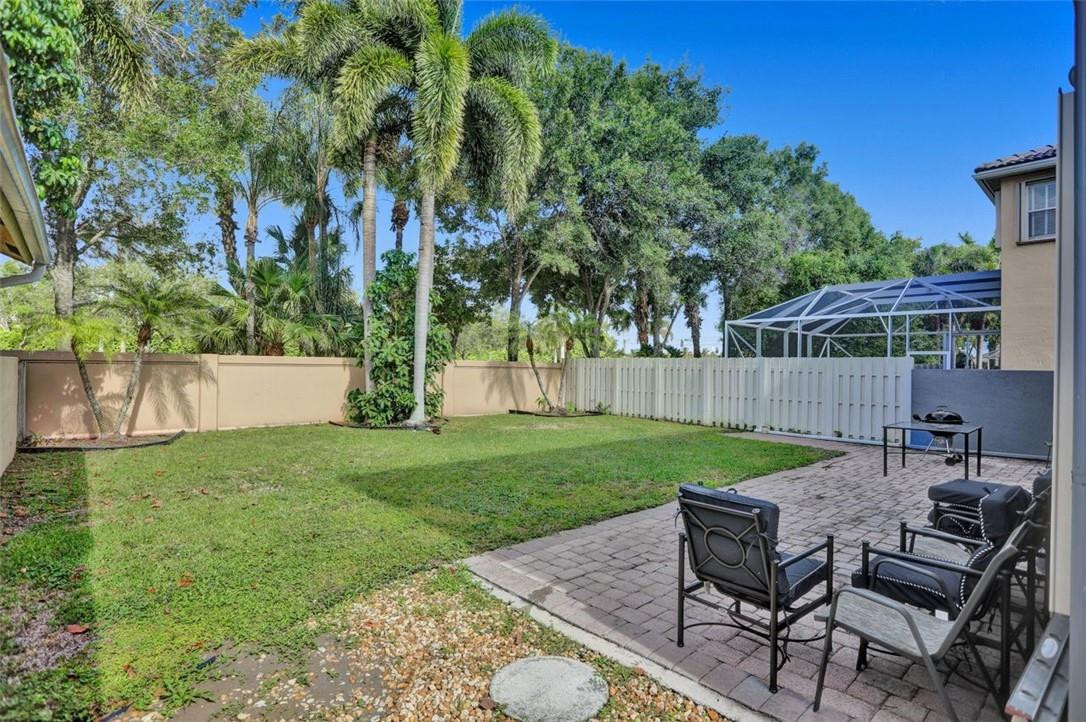 5257 Sancerre Circle Lake Worth, FL 33463 - Photo 5 of 46 a view of a backyard with table and chairs and potted plants
