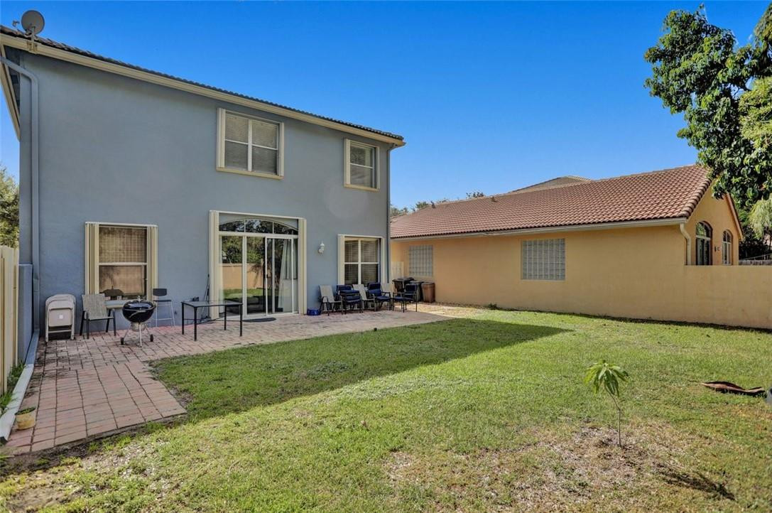 5257 Sancerre Circle Lake Worth, FL 33463 - Photo 7 of 46 a view of a backyard with table and chairs potted plants and a large tree