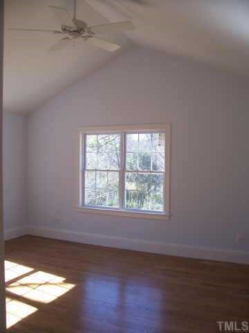813 Chamberlain Street Raleigh, NC 27607 - Photo 6 of 9 an empty room with wooden floor and windows