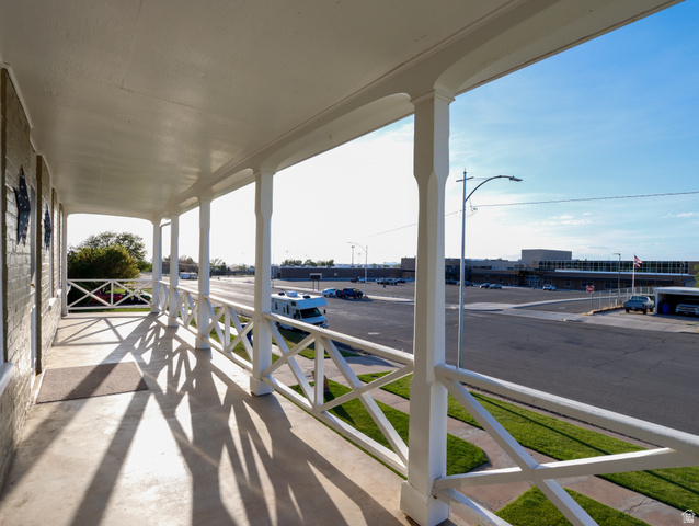 155 West Center Street Fillmore, UT 84631 - Photo 54 of 86 Covered porch with white painted columns and railing, featuring a concrete surface and a brick exterior wall