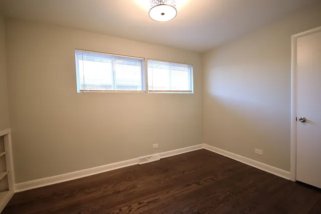 a view of a room with wooden floor and windows
