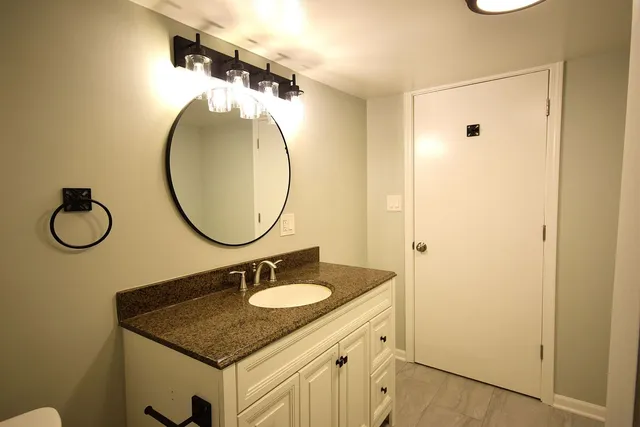 a bathroom with a granite countertop sink and a mirror