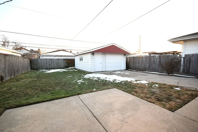 a view of a house with a small yard and a wooden fence
