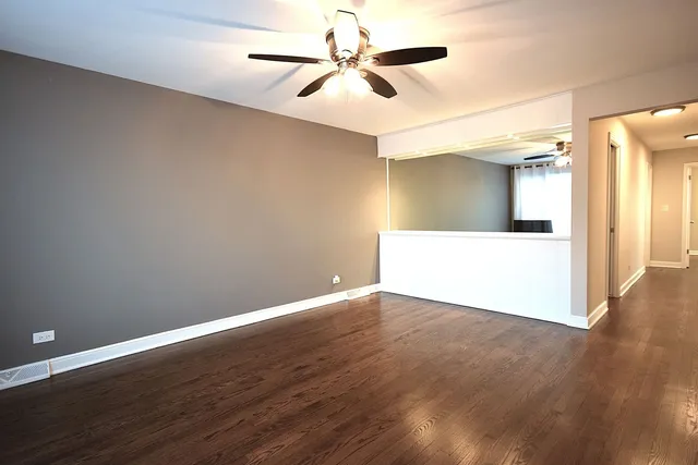 a view of a big room with wooden floor and a ceiling fan